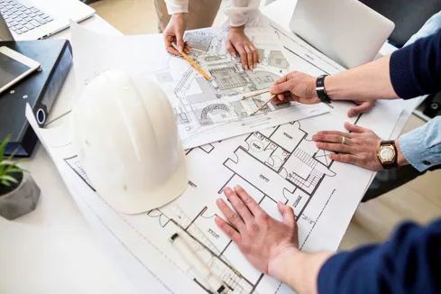 Ingenieros revisando planos de un proyecto eléctrico